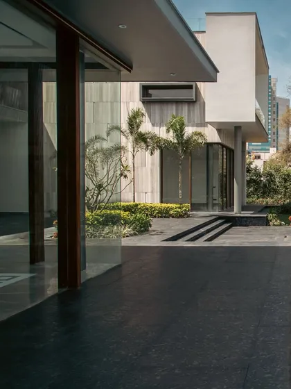 The clean lines and geometric forms of the Rosewood Farmhouse. The architecture steps back to allow pockets of greenery to thrive, creating a seamless transition between the built structure and the landscape.