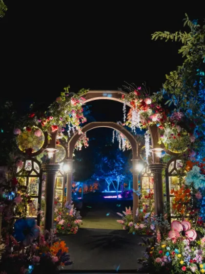 The full view of the magical entrance archway at night, leading guests into the enchanted garden-themed Sangeet.