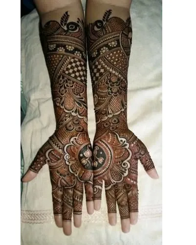 This full-arm design is packed with intricate details. It features circular mandala patterns on the palms and peacock motifs at the top, all connected with fine line work.