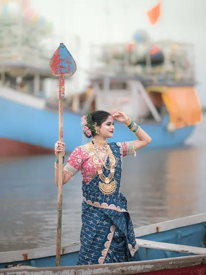 Posing with an oar against the backdrop of fishing boats. Every element in this photo contributes to the story.
