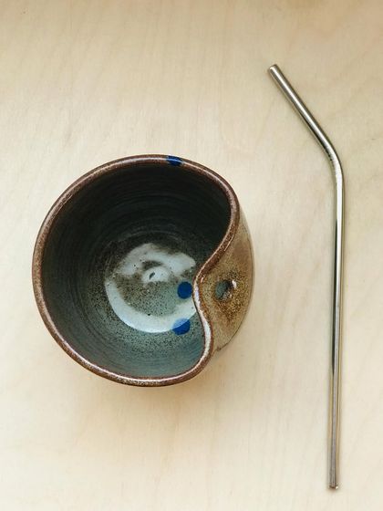 Introducing the "Sip Buddy," a sippable ceramic cup with a dedicated slot for your reusable straw. This one features an earthy glaze with playful blue polka dots.