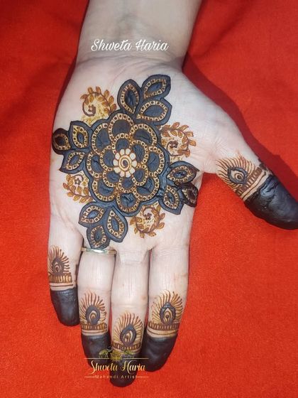 A simple yet striking floral mandala on the palm, using a dual-tone technique to create a bold, 3D effect.