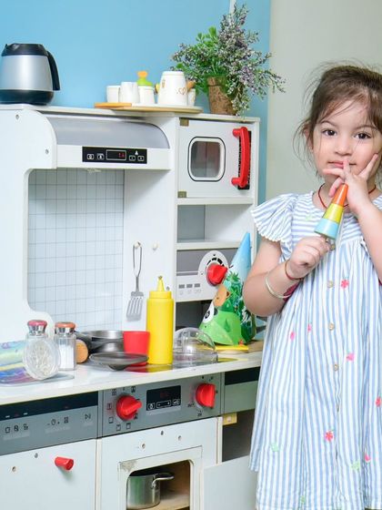 Enjoying a pretend ice cream cone in her happy place. Our play kitchen is stocked with all sorts of fun toy foods.
