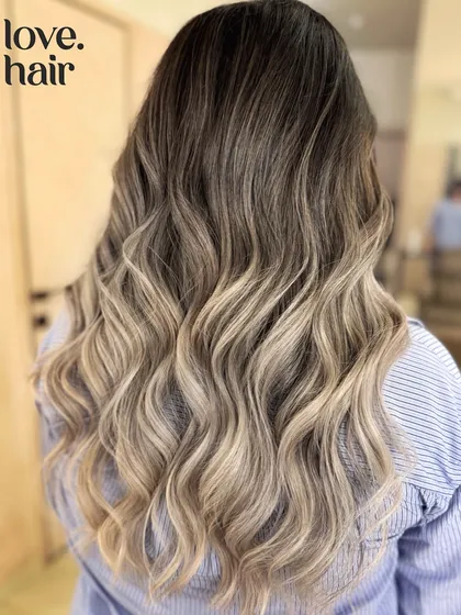 Sipping bubbly, feeling lovely. A gorgeous champagne blonde balayage that transitions from a natural root to bright, platinum ends.