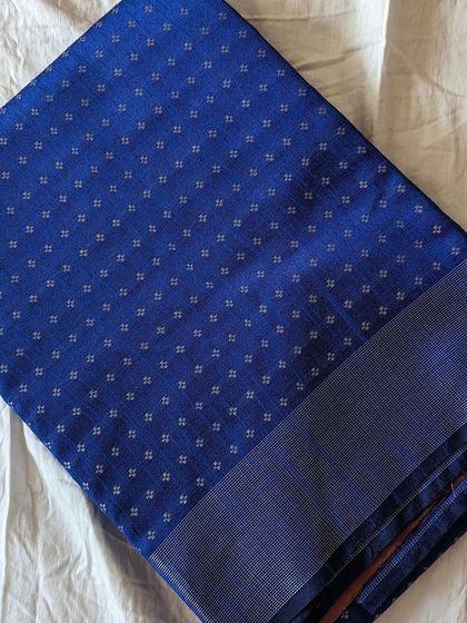A new edit of semi raw silk sarees. This royal blue piece with small butti work is the epitome of traditional elegance.