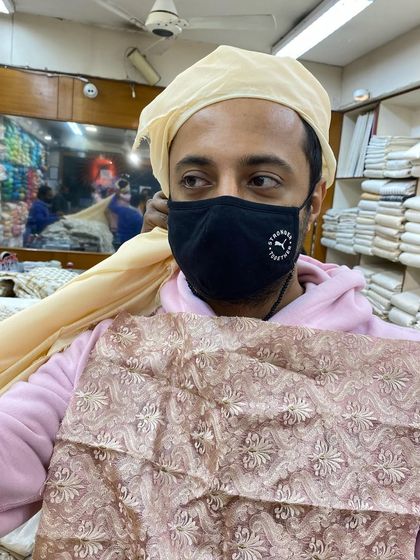 The process of perfecting a groom's look. For this peach sherwani, finding the right safa was key. We chose a beige cloth with a delicate lace that matched the sherwani's fabric swatch perfectly.