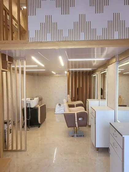 The stylish and well-lit interior of our salon, featuring modern styling stations and a comfortable waiting area. We prioritize a clean and professional environment for our clients.