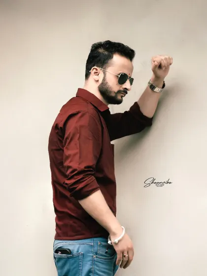 A stylish and modern individual portrait. This simple, clean shot against a plain wall is perfect for a profile picture or portfolio.