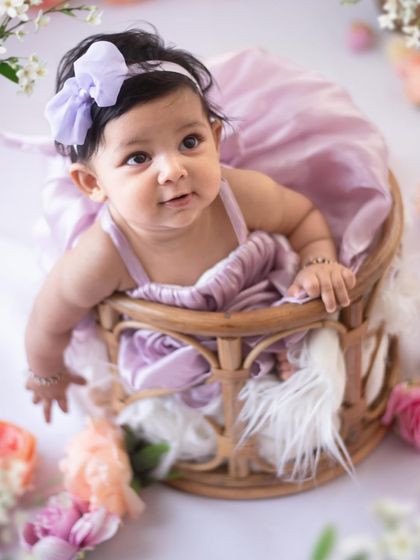 A simple and sweet floral theme for a sitter session. This baby girl looks so lovely in her lavender dress, sitting in a rustic cane basket surrounded by soft flowers.