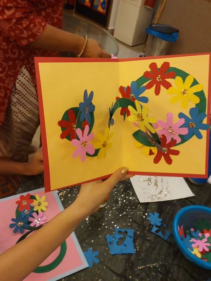 A close-up of a finished Mother's Day pop-up card. The intricate papercraft and bright colors make for a wonderful surprise.