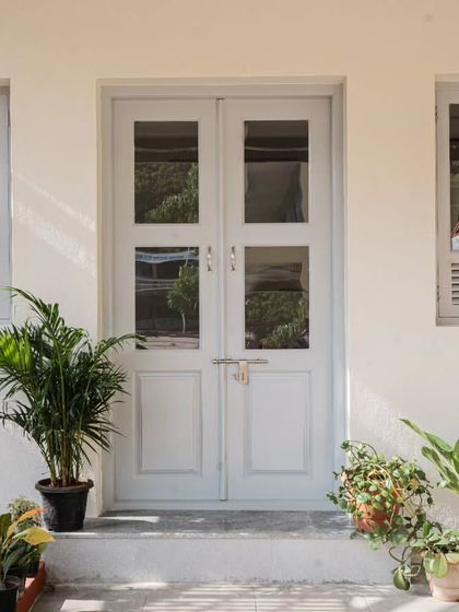 The entrance to the classroom is marked by a large central door flanked by louvered teak windows. This symmetrical and functional design allows for excellent cross-ventilation and fills the room with diffused natural light, creating a welcoming and pleasant learning environment.