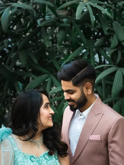 A classic portrait of the couple looking at each other. The simple green background keeps the focus entirely on their interaction.