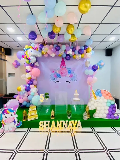A beautiful Unicorn theme setup with a large unicorn face backdrop, pastel balloons, and a unicorn figure made of balloons.