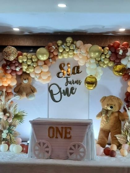 A cute and cuddly teddy bear theme for a first birthday, using a neutral color palette of brown, beige, and gold with adorable bear props.