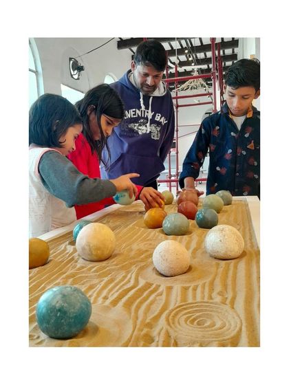 A family interacts with our Tadelakt spheres display. These smooth, colorful orbs allow visitors to feel the unique, waterproof finish of this traditional lime plaster.