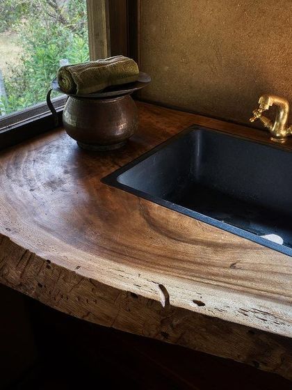 A live-edge wood counter provides a natural, organic surface in the cottage's kitchen area.