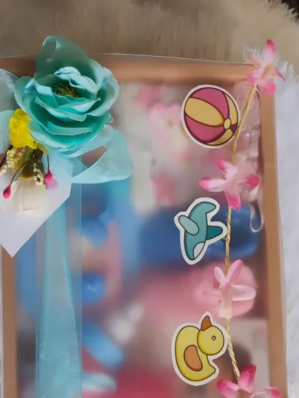 The baby shower hamper, packaged in a slider box with a decorative banner.