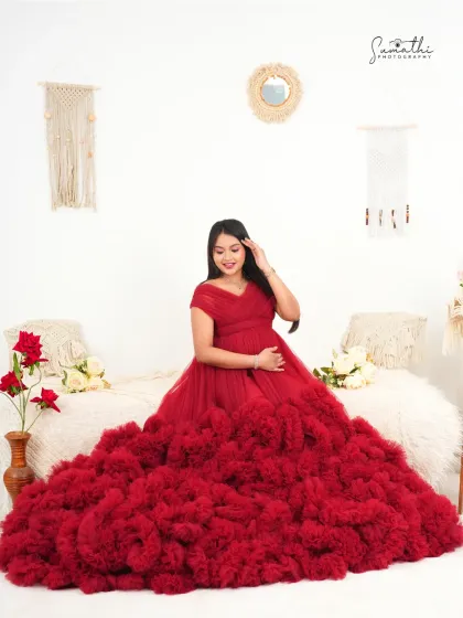 A beautiful solo portrait in a dramatic red ruffled gown. The simple, boho-inspired bed setup allows the gown and the mother-to-be's glow to be the main focus.