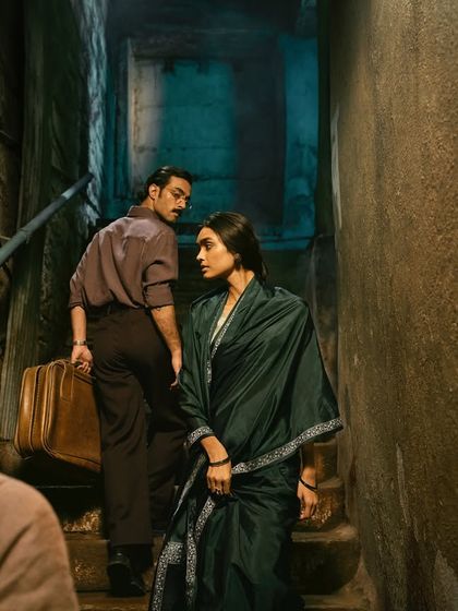 The story continues as the couple moves through the narrow Banaras alley. The vintage suitcase is a key prop that adds to the narrative of a journey or an escape.