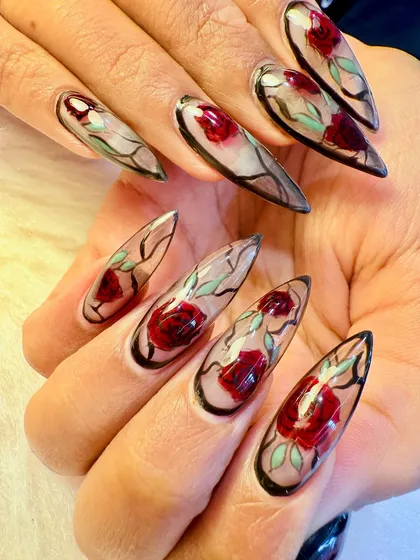 A full view of our hand-painted glass rose nails. The sharp stiletto shape and the incredible detail in the artwork make this one of our most requested high-fashion looks.