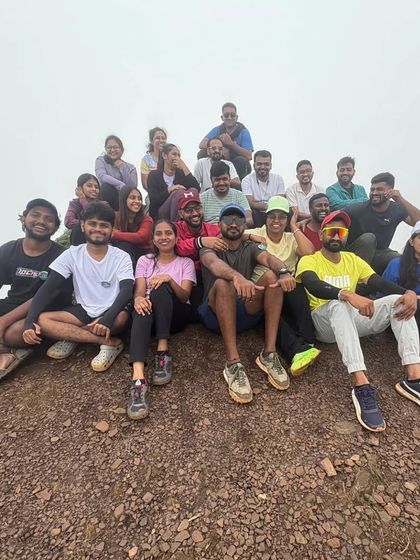 Chilling at the top. A group relaxes on the rocky summit after a challenging but rewarding climb.