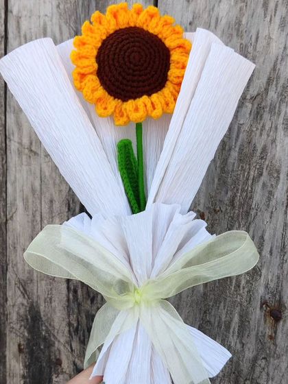 The single sunflower bouquet against a wooden background.