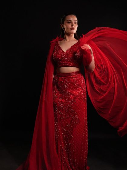 The flowing red cape adds a touch of drama and movement to this powerful and glamorous outfit. Perfect for making a grand entrance.