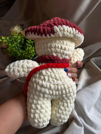 The back view of our mushroom plushie, showing the soft texture of the chunky yarn. It's a perfect decorative piece for a woodland-themed nursery.
