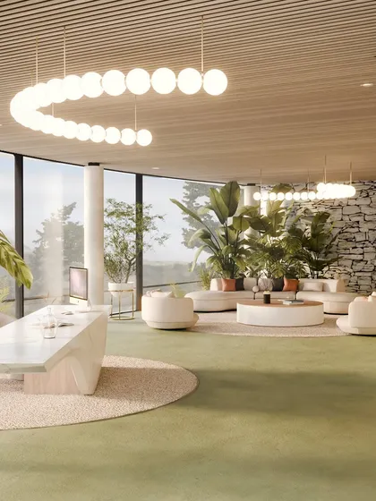 A wide view of the reception and lounge, where modern furniture and lighting contrast with the raw, natural stone wall.