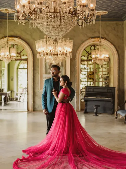 For a touch of royal elegance, this magenta trail gown is a favorite for pre-wedding shoots. Its long, flowing train spreads out beautifully against the grand backdrop of this palace hall, creating a truly cinematic and romantic photograph.