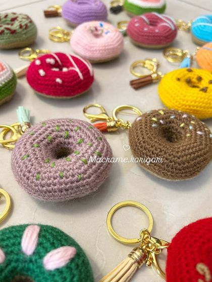 Who loves donuts? Our crochet donut keychains look good enough to eat. This photo shows a variety of "flavors" and "toppings," each one handcrafted with colorful yarn.