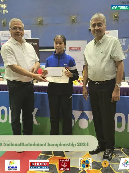 A young female player receiving her certificate at the Mini National Badminton Championship.
