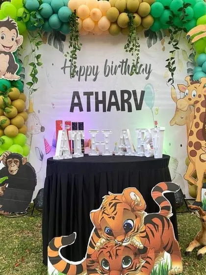 A fun-filled outdoor Jungle Book birthday party. We transformed this garden space with a lush green balloon arch, and character cutouts of Mowgli, Baloo, and Shere Khan, bringing the jungle adventure to life.