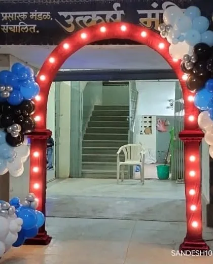 A lighted entrance arch decorated with blue, black, and white balloons for a "Boss Baby" themed party, welcoming guests to the event.