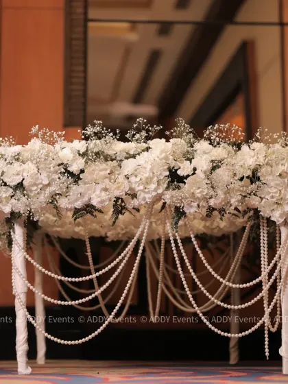 A statement piece for the Nikah ceremony. This signing table is completely covered in white hydrangeas and baby's breath, with elegant pearl strings cascading down the sides.