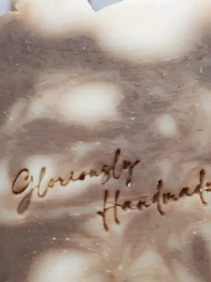 A detailed close-up of the "Gloriously Handmade" stamp on my Neem Cucumber soap. This is my personal seal of quality and care on every bar I make.