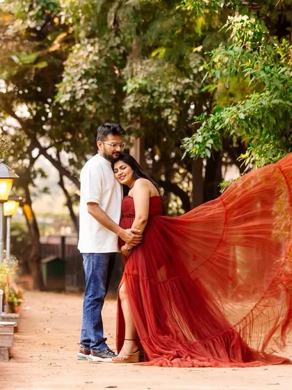 A dynamic outdoor maternity photo where the mother-to-be's vibrant red gown flows in the wind. This shot combines romance with a touch of drama, creating a stunning visual.