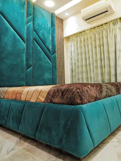 I believe your bedroom should have a personality. This master bedroom features a bold, geometric headboard in a rich teal velvet, creating a space that feels both luxurious and uniquely different.