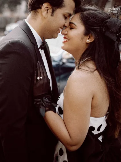 A sweet and happy close-up. Her retro-inspired polka dot dress and his classic suit create a charming and timeless look, perfect for this romantic, nose-to-nose moment.