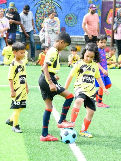 A young player practices ball control under the watchful eye of her teammate and the parents on the sidelines. Our training sessions are a community event.
