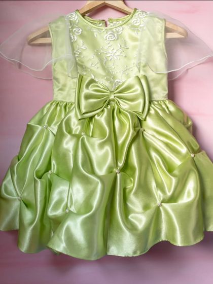 I designed this vibrant lime green satin gown to make a bold and joyful statement. The structured bubble skirt and oversized bow create a fun, high-fashion silhouette that's perfect for a birthday girl who loves to stand out.