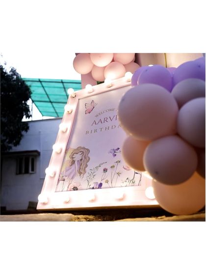 Another angle of the light-up welcome sign for Aarvi's fairy party, showing the soft glow of the marquee lights and the delicate artwork.