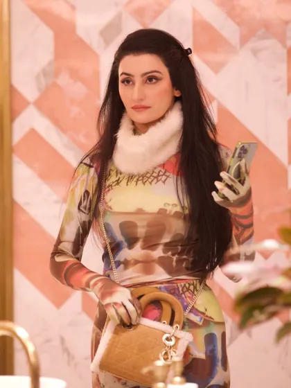 This custom Huemn catsuit, featuring a unique print and paired with a faux fur collar and boots, was a bold, avant-garde look for the show. It's a great example of pushing fashion boundaries.