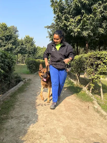 Proving that women can absolutely train big, strong dogs. Here I am with Phantom, a German Shepherd, practicing a focused heel during an outdoor session. A calm, structured walk is foundational for a well-behaved dog.