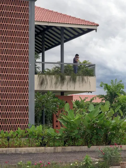 The upper-level terrace offers an open, covered space for enjoying the views, with lush greenery cascading over the edge.