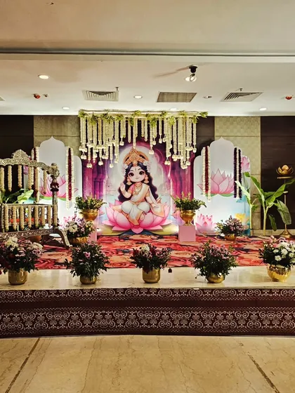 This beautiful cradle ceremony was designed to welcome a baby girl with a 'Baby Lakshmi' theme. The stage features a custom printed backdrop of the goddess, elegant floral arrangements, and a traditionally decorated swing.