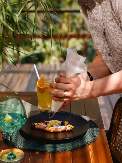 A chef adds the finishing touches to our signature mango and blueberry croissant.