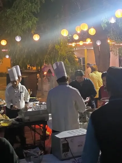 Guests being served by our chefs at a live food counter. This interactive element is always a popular feature, allowing guests to see their food being made and customize their plates.