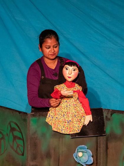 A close-up of the Aisha puppet, showing the detailed craftsmanship and expressive face that helps her connect with the audience.