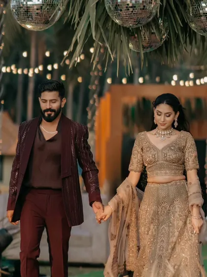 The couple makes their grand entrance at the Sangeet. The decor features a mix of rustic elements and glamorous disco balls, perfectly capturing the "rustic glitz" theme of the evening.